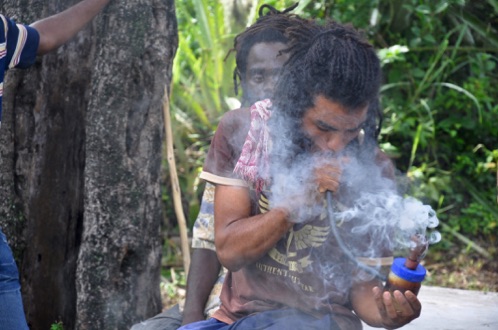 Rasta smokes a chalice 
Kingston Jamaica